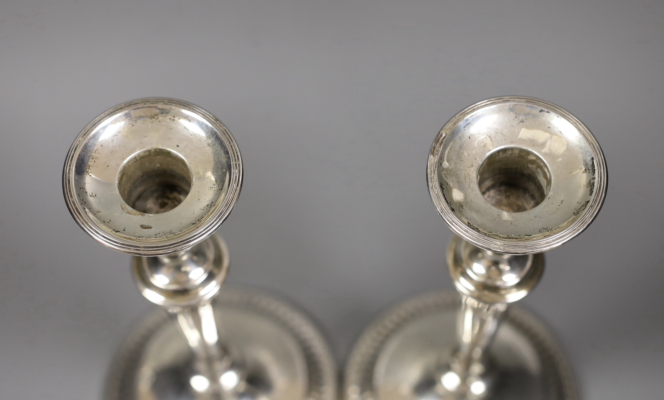 A pair of George V silver candlesticks, with panelled tapering stems, Thomas Bradbury & Sons, Sheffield, 1919, height 24cm.